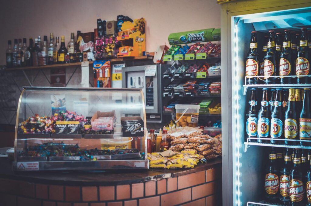 A well-stocked convenience store counter with snacks, drinks, and a refrigerator showcasing beverages.- ADHD Impulsivity