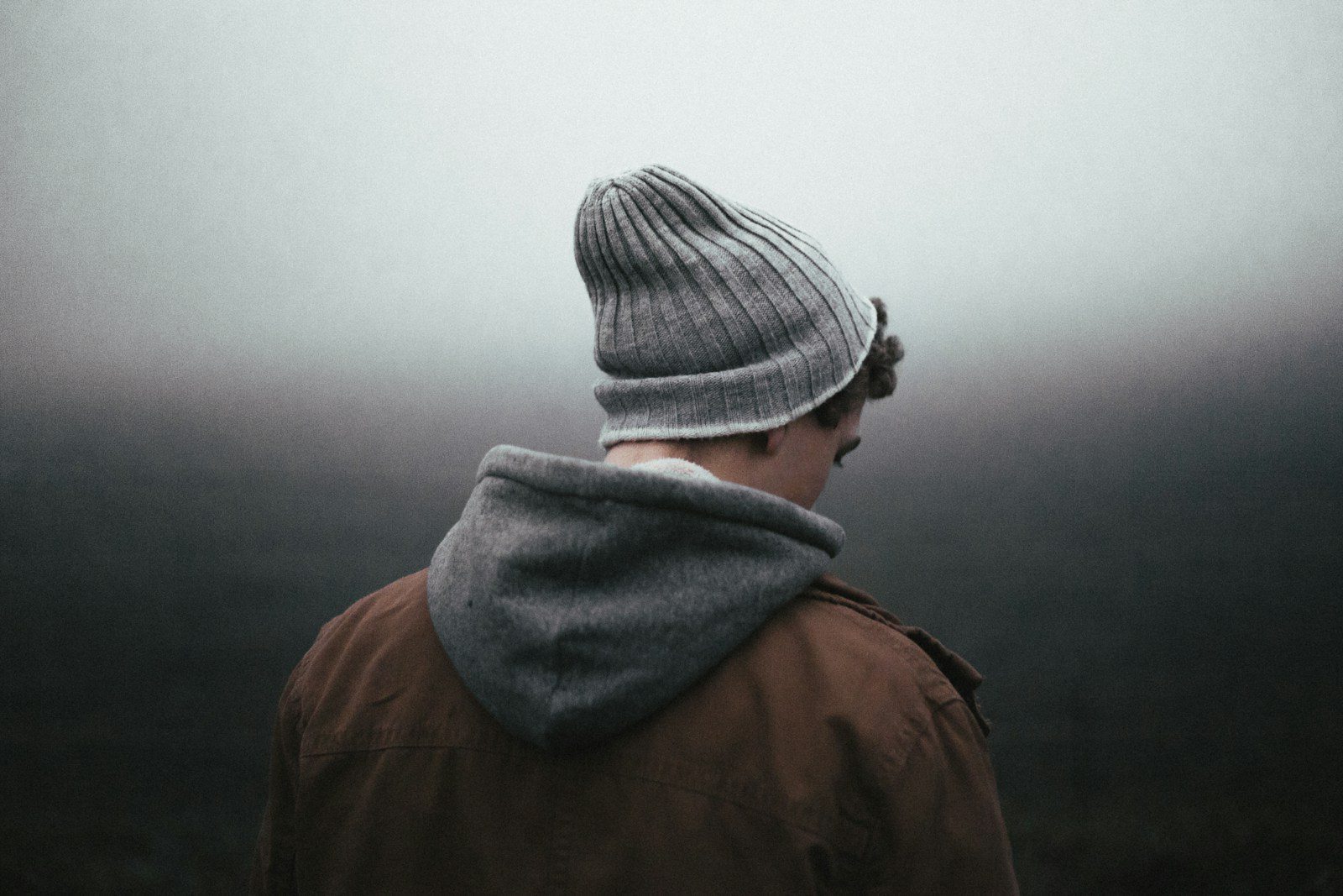 man wearing knit cap on grey background - ADHD meltdown vs autism meltdown