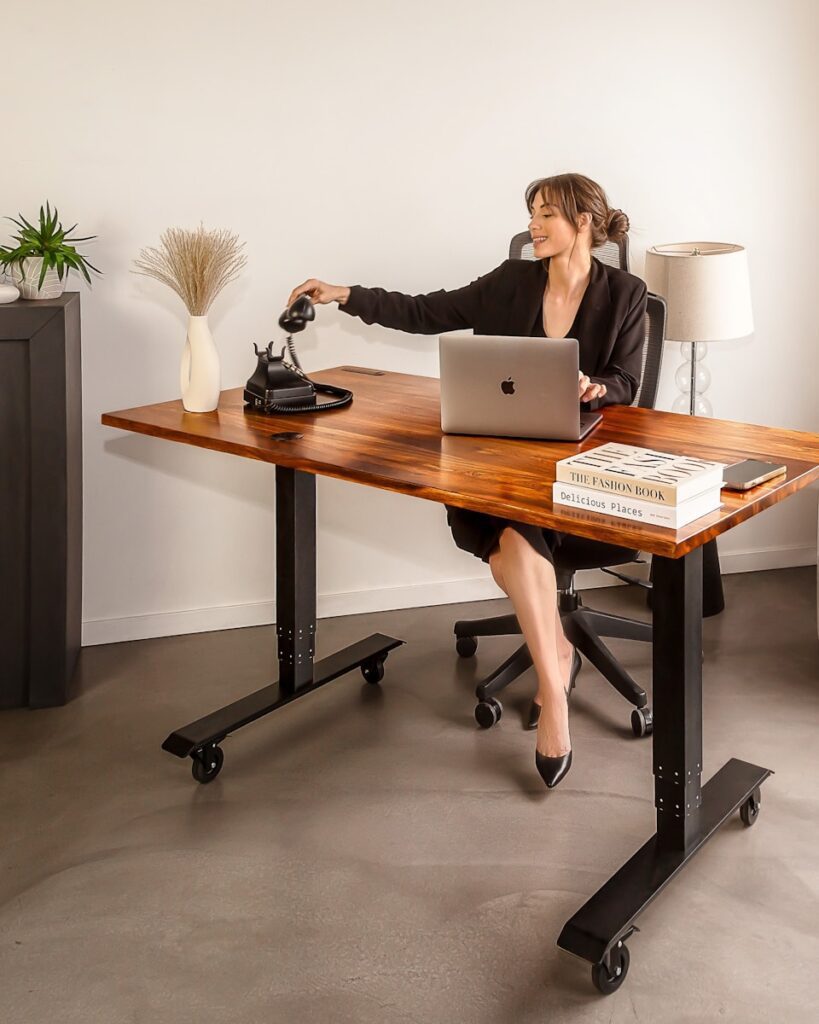 a woman sitting at a desk with a laptop - adhd coaching uk