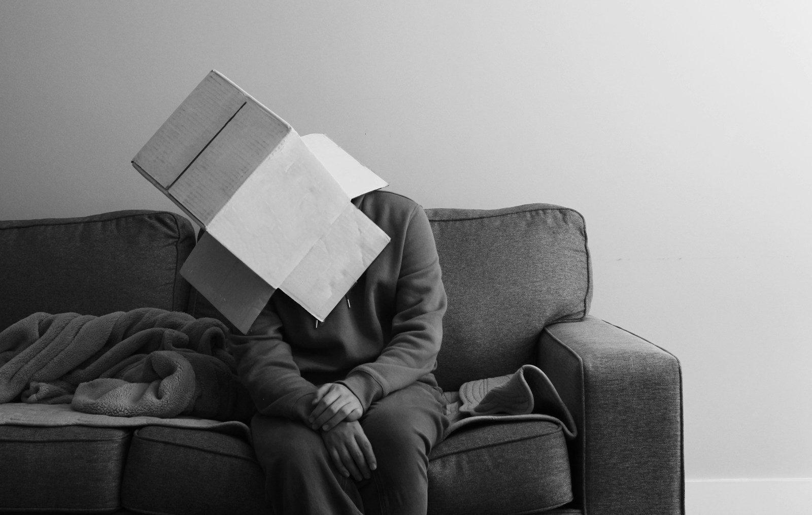 a person sitting on a couch with a book on their head - what adhd feels like