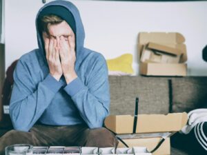 man covering face with both hands while sitting on bench - the adhd burnout cycle